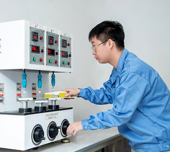 a male engineer conducting button life testing with a device