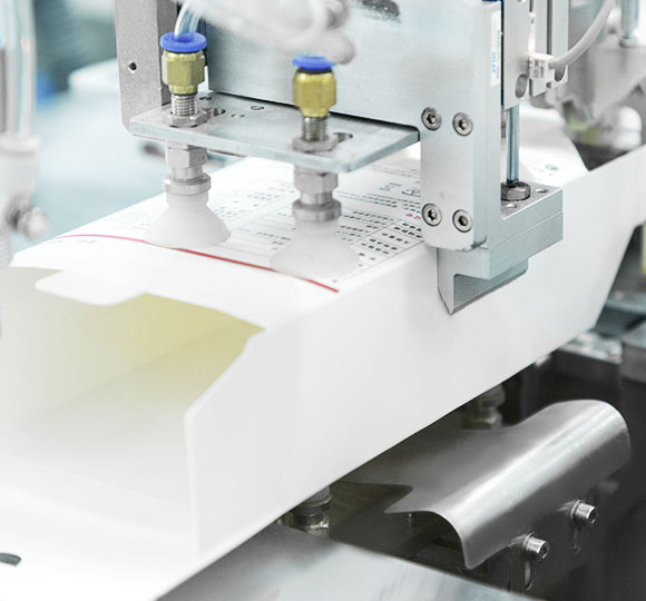 a machine is folding a packaging box for the infrared thermometer