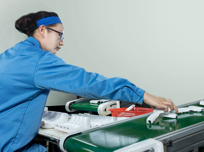 a female worker is reaching for conveyor